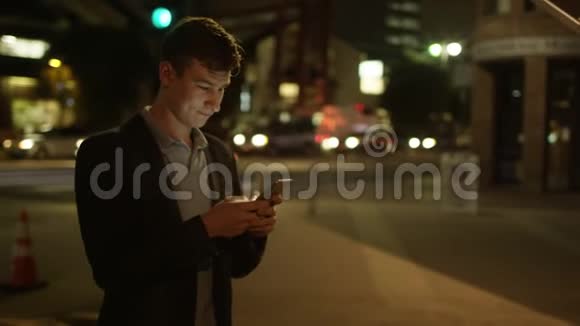 年轻的帅哥在街上发短信视频的预览图