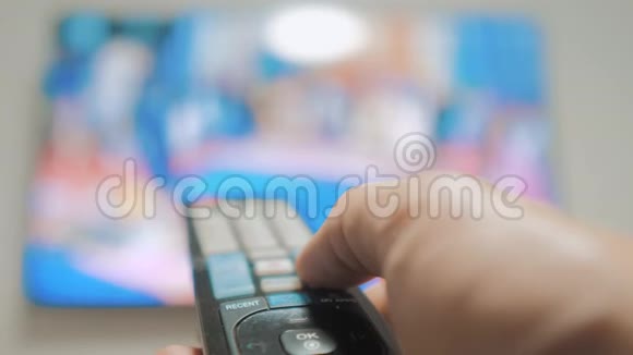人手握电视遥控器关掉智能电视频道冲浪密切男人手中的生活方式拿着电视视频的预览图