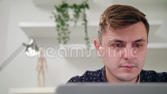 一个年轻人在室内使用笔记本电脑视频的预览图