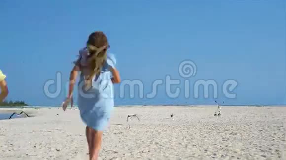 小女孩在热带海滩玩得开心一起在海滨玩耍视频的预览图
