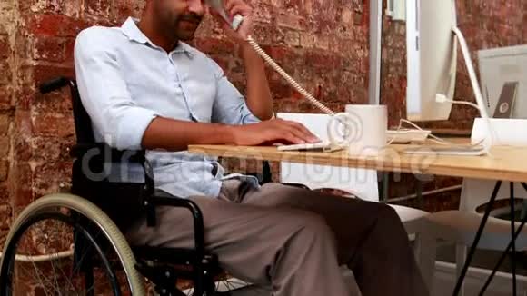 坐轮椅在办公桌前工作的临时商人视频的预览图