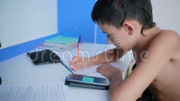 十几岁的男孩用手机做作业自然视频视频的预览图