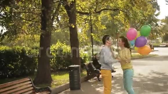 一对情侣在公园里玩着五颜六色的气球视频的预览图