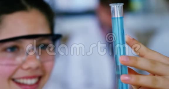 微笑的女学生在实验室做化学实验视频的预览图