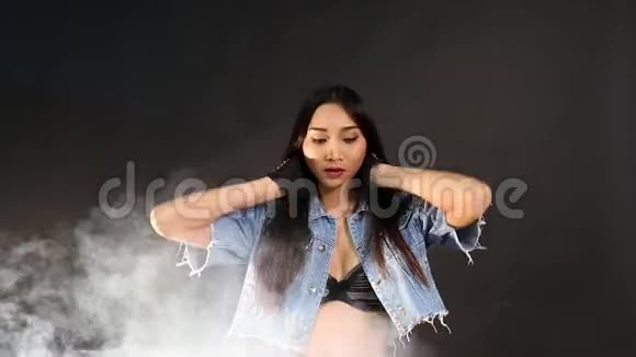 黑色背景下的女人带着雾烟和从后面的光线视频的预览图