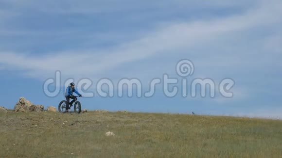 夏天骑着肥肥的自行车或肥肥的自行车穿过山丘视频的预览图