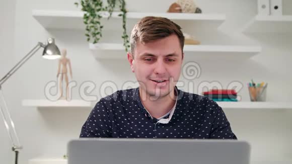 一个年轻人在室内使用电脑视频的预览图