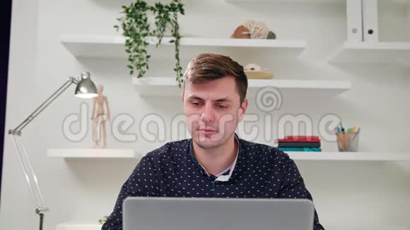 一个年轻人在室内使用电脑视频的预览图