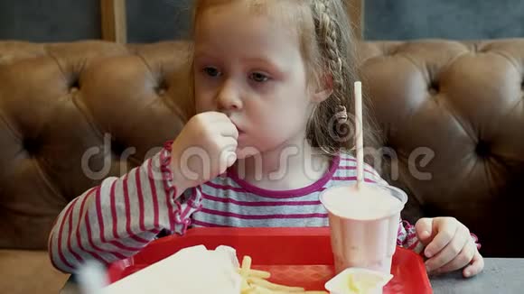 可爱的女孩在咖啡馆里吃着美味视频的预览图