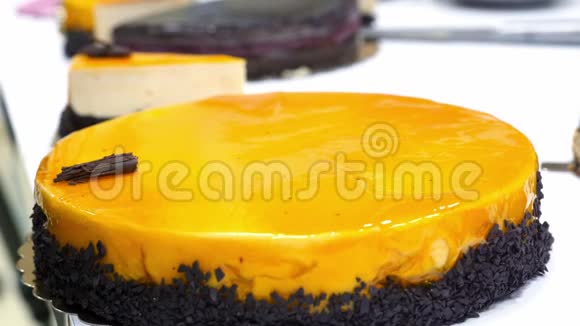 一个糖果师用巧克力装饰一个橙色蛋糕视频的预览图