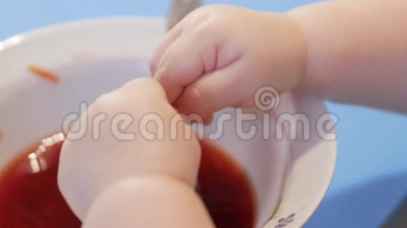 一个有魅力的2岁男孩用手爬上汤里用手摸着配料特写视频的预览图