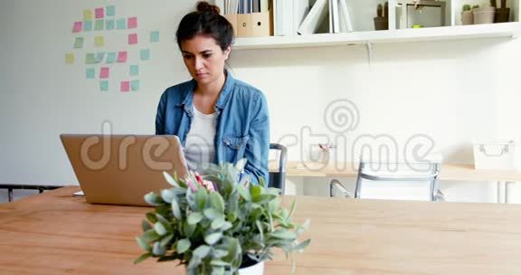女性行政人员坐在办公桌上使用笔记本电脑视频的预览图