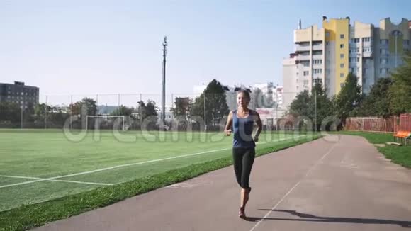 健身女运动员在体育场跑道上跑步视频的预览图