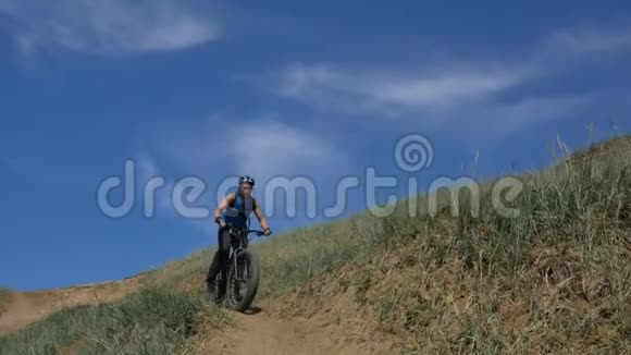 胖自行车也被称为胖自行车或胖轮胎自行车在夏天开车在路上视频的预览图