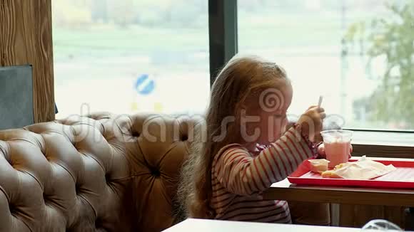 可爱的女孩在咖啡馆里吃着美味视频的预览图