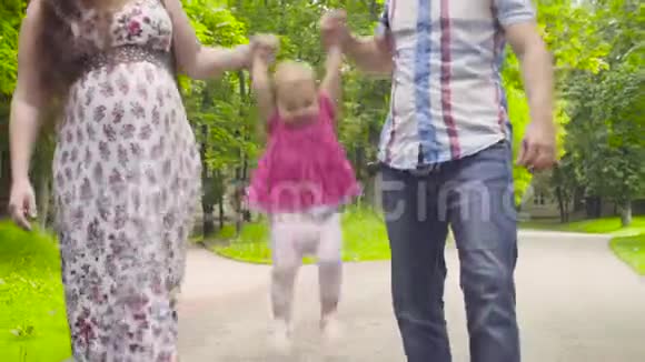 快乐的父母和小女孩在公园散步视频的预览图