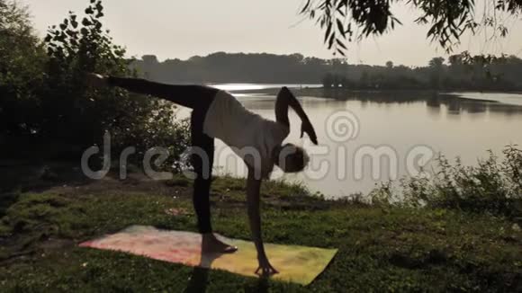 日落时分在户外练习瑜伽的年轻女子视频的预览图