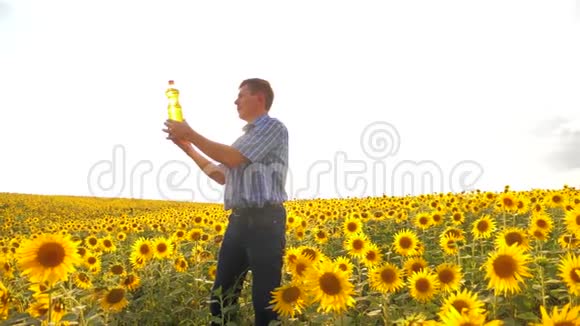 老农葵花油概念农业农夫手里拿着一个塑料瓶葵花籽油站着视频的预览图