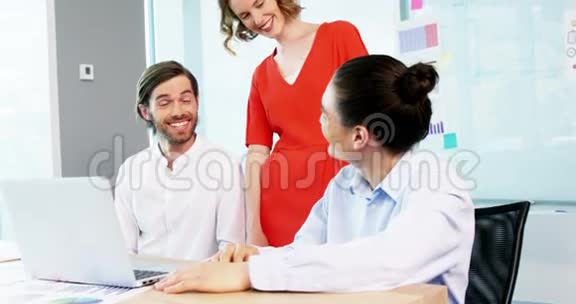 微笑的商务同事在会议室讨论笔记本电脑视频的预览图