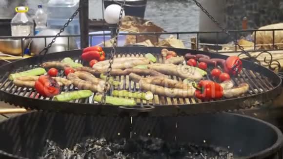 烧烤炉上烹饪烧烤美味香肠和蔬菜视频的预览图