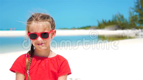 暑假期间在海滩上可爱的小女孩的肖像慢动作视频的预览图
