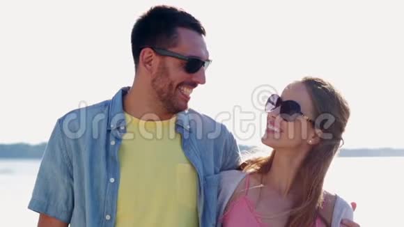 快乐的一对夫妇戴着太阳镜拥抱大海视频的预览图