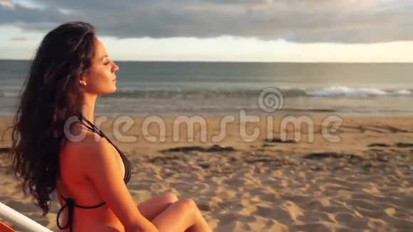 冷静的黑发女人坐在躺椅上放松视频的预览图
