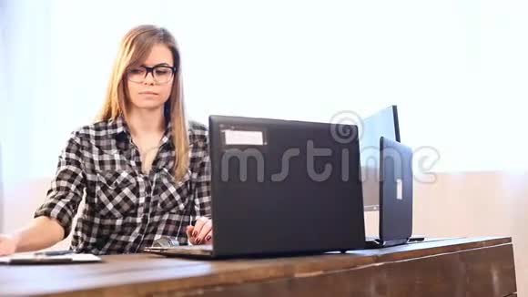 商务女孩坐在办公室文件夹的电脑前视频的预览图