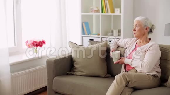 家里有一杯茶或咖啡的老妇人视频的预览图