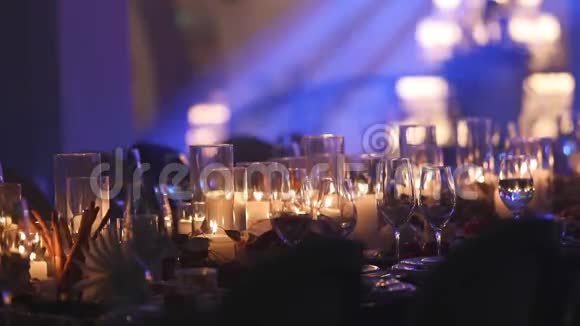 餐桌上的装饰蜡烛桌子上的眼镜和圣诞蜡烛带玻璃的白色蜡烛视频的预览图