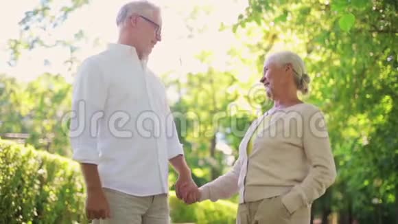 快乐的老两口在夏季城市公园散步视频的预览图
