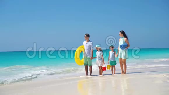在热带海滩度假快乐美丽的四口之家视频的预览图