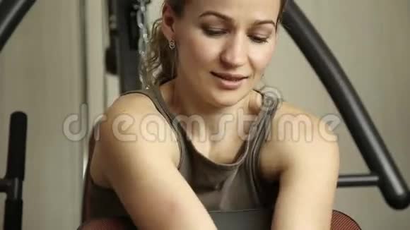 健身女孩带着哑铃在健身房做运动视频的预览图