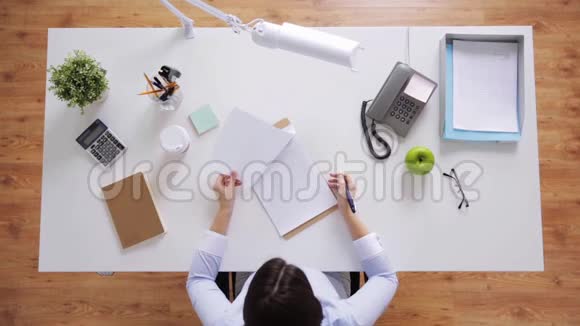办公桌上拿着文件的女商人视频的预览图