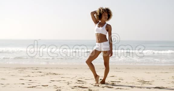 健身年轻女子站在海滩上视频的预览图