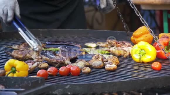 烧烤炉上烹饪烧烤美味香肠肉类和蔬菜慢动作视频的预览图