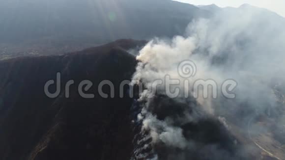 一座被浓烟笼罩的山峰的空中镜头视频的预览图