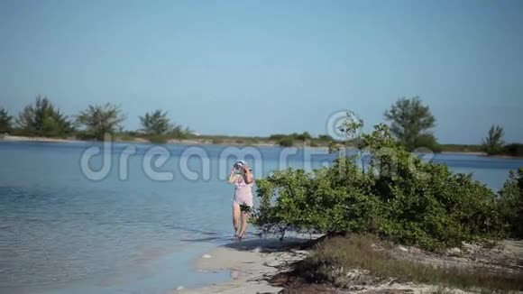 年轻的金发女人在海滩上散步视频的预览图