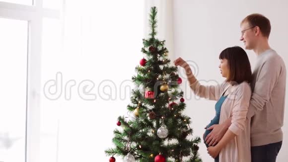 幸福的夫妻在家装饰圣诞树视频的预览图