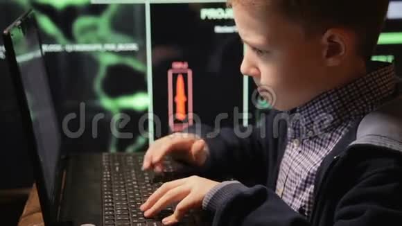 少年神童黑客在工作的黑客电脑屏幕上有很多数字视频的预览图