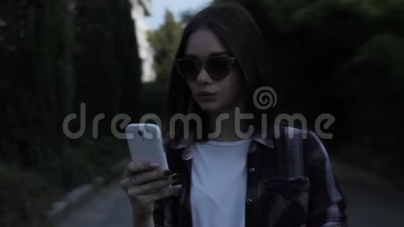 年轻漂亮的女孩带智能手机户外视频的预览图