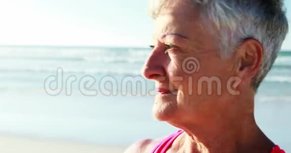 微笑着站在海滩上的高级女人视频的预览图