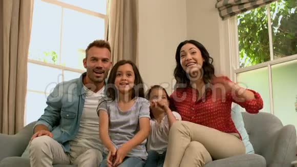 幸福的家人在沙发上欢呼视频的预览图