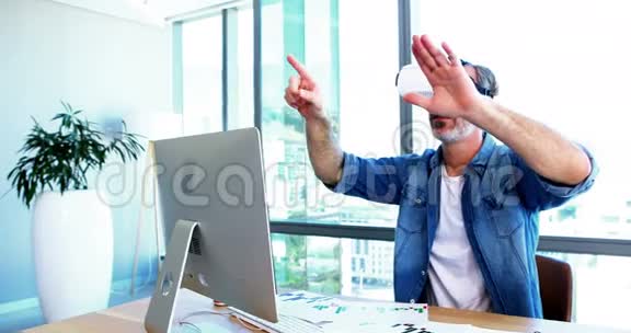 办公桌上使用虚拟现实耳机的男性高管视频的预览图