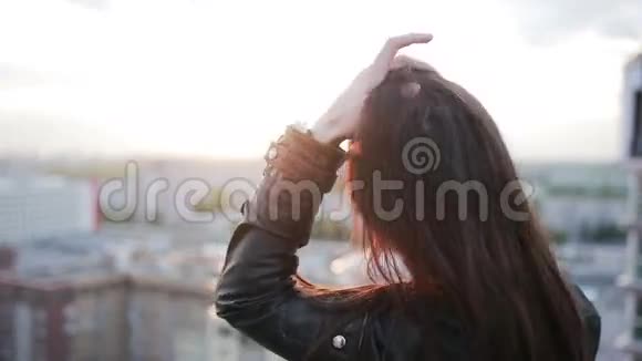 日落时站在屋顶上的女孩视频的预览图