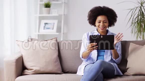 快乐的美国妇女与平板电脑在家视频的预览图