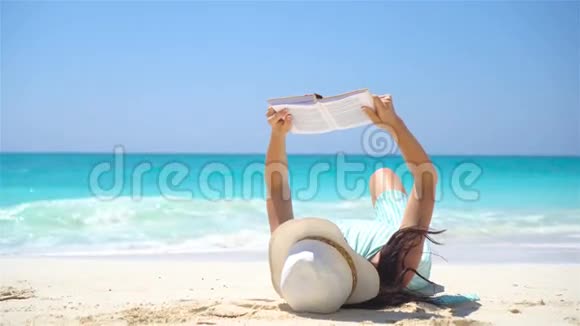 年轻女子正在热带海滩读书视频的预览图