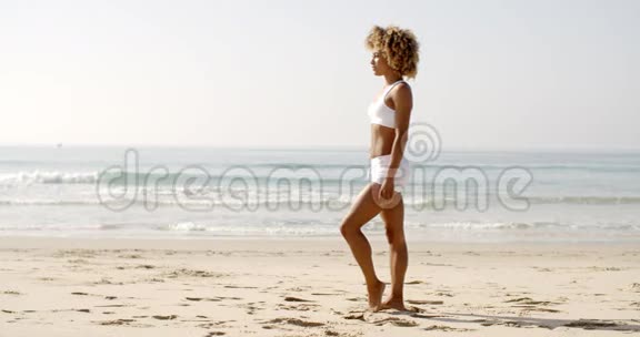 健身年轻女子站在海滩上视频的预览图