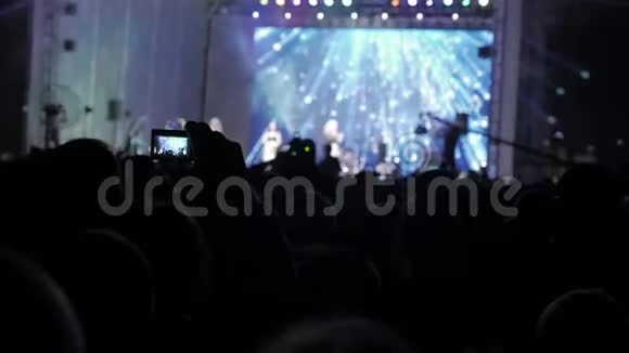 音乐音乐会上的人群在明亮多彩的舞台灯光前喧闹的人群生活方式剪影视频的预览图