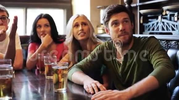 喝啤酒的朋友在酒吧或酒吧看足球视频的预览图